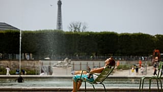 A woman enjoys the sun in the Tuileries gardens, in Paris.