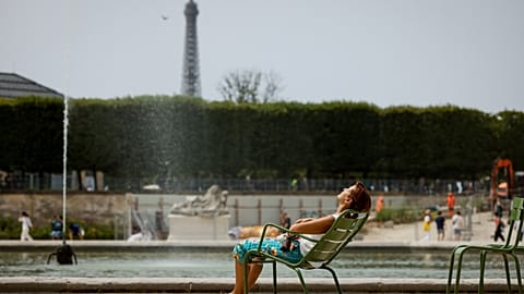 A woman enjoys the sun in the Tuileries gardens, in Paris.