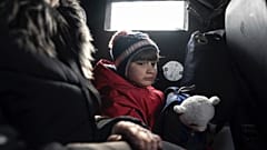 Ein Mädchen fährt mit seiner Mutter in einem Lieferwagen während der Evakuierung durch die ukrainische Polizei in Avdiivka, Ukraine, Dienstag, 7. März 2023. 