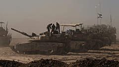 Israelische Soldaten stehen auf dem Dach eines Panzers, der in der Nähe der Grenze zwischen Israel und Gaza geparkt ist, vom Süden Israels aus gesehen, Montag, 18. August 2025. 