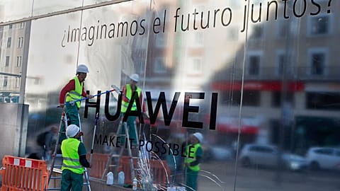 Workers clean the front of Huawei's new flagship shop which opened in Madrid, Spain, Wednesday, May 22, 2019.