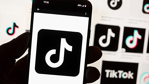 FILE - The TikTok logo is displayed n a mobile phone in front of a computer screen displaying the TikTok home screen, Oct. 14, 2022, in Boston.