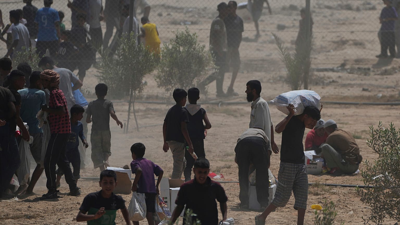 الفلسطينيون يجمعون المساعدات الإنسانية  في دير البلح بوسط قطاع غزة، الثلاثاء 19 أغسطس 2025.