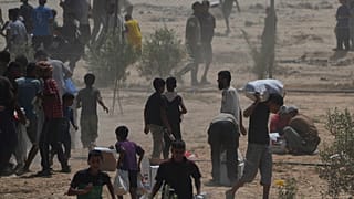 الفلسطينيون يجمعون المساعدات الإنسانية في دير البلح بوسط قطاع غزة، الثلاثاء 19 أغسطس 2025.