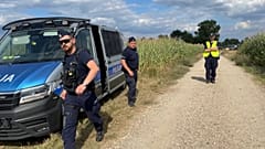 Police secure a cornfield where an unidentified flying object crashed and exploded in Osiny, 20 August, 2025