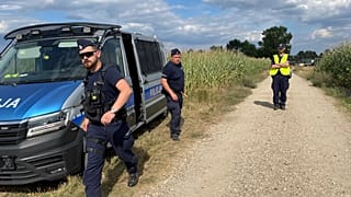 Police secure a cornfield where an unidentified flying object crashed and exploded in Osiny, 20 August, 2025