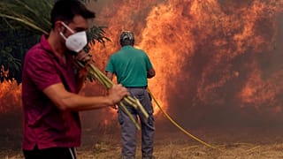 Des habitants luttent contre un incendie de forêt qui progresse vers le village de Rebordondo, près d'Orense, dans le nord-ouest de l'Espagne, le lundi 18 août 2025.