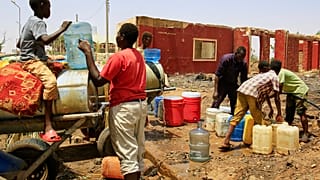 يملأ الناس حاويات بالمياه عند نقطة توزيع بسبب انقطاع المياه في الخرطوم، السودان، الأحد 25 مايو 2025