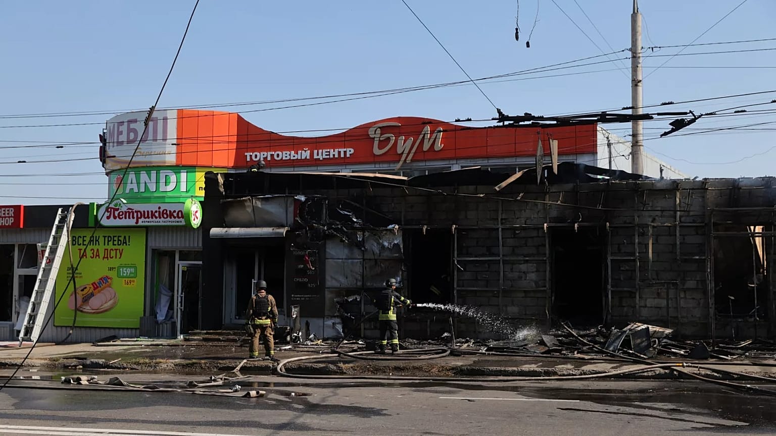 Equipas de salvamento apagam um incêndio em lojas comerciais destruídas por um ataque de mísseis russos em Zaporizhzhia, 18 de agosto de 2025