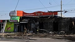 Rettungskräfte löschen ein Feuer in einem Geschäft, das durch einen russischen Raketenangriff in Saporischschja zerstört wurde, 18. August 2025