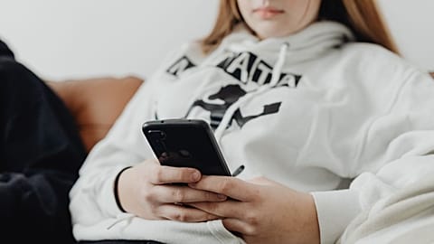 Девочка-подросток пользуется своим смартфоном.