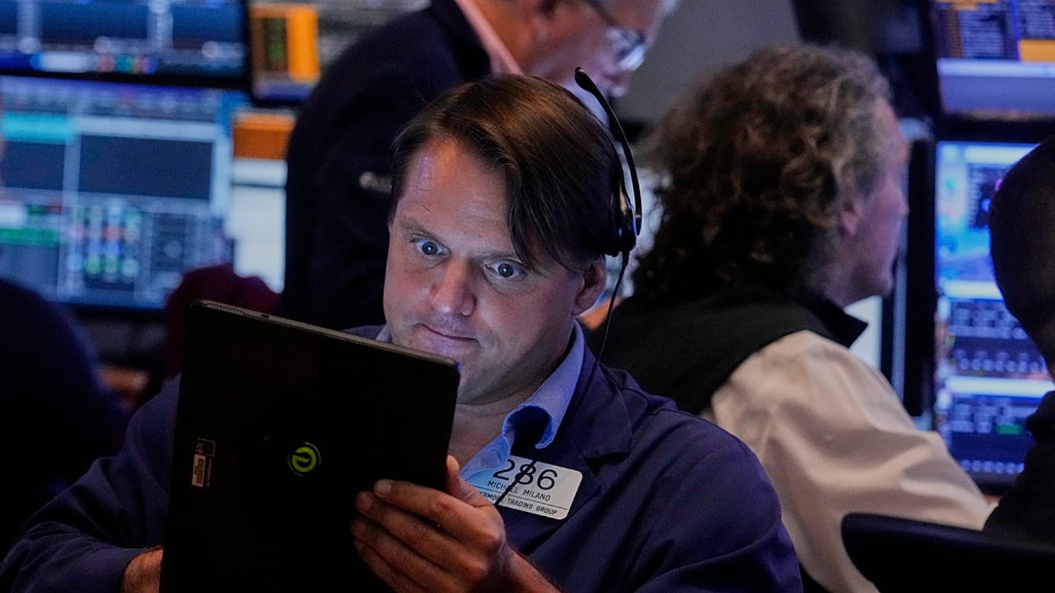 Trader Michael Milano left, works on the floor of the New York Stock Exchange, Monday, Aug. 18, 2025. 