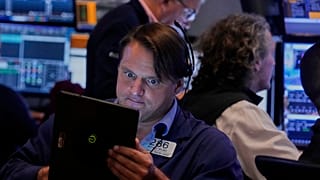 Trader Michael Milano left, works on the floor of the New York Stock Exchange, Monday, Aug. 18, 2025. 