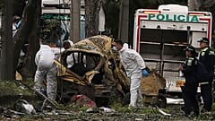 Des médecins légistes inspectent le site de l'explosion d'une bombe à l'extérieur d'une base de l'armée de l'air à Cali, en Colombie, le jeudi 21 août 2025. 