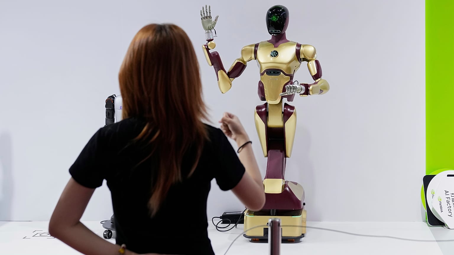 An exhibitor gives command to a robot at Nvidia's booth during the 3rd China International Supply Chain Expo at the China International Exhibition Center, in Beijing, China, F