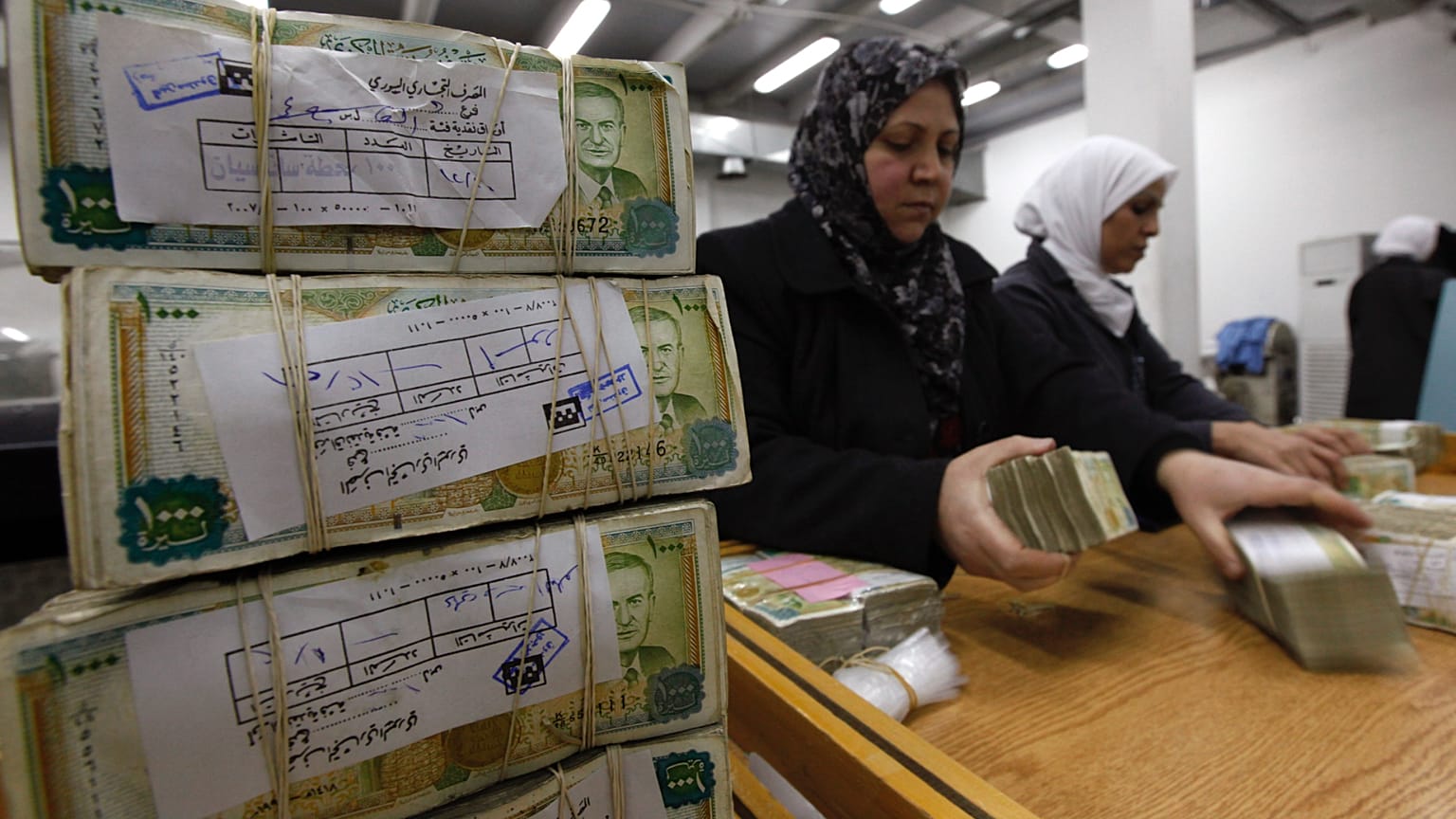 موظفون يقومون بتكديس العملة السورية في البنك المركزي في دمشق، سوريا، 13 يناير/كانون الثاني 2010