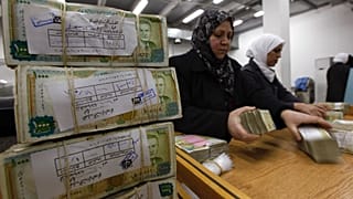 موظفون يقومون بتكديس العملة السورية في البنك المركزي في دمشق، سوريا، 13 يناير/كانون الثاني 2010