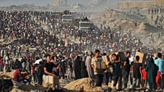 Palestinians carry sacks and boxes of food and humanitarian aid unloaded from a World Food Programme convoy in northern Gaza, 16 June, 2025