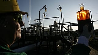 A worker examines a sample at the receiving station of the oil pipeline 'Druzhba , in Hungary on Thursday, Jan. 11, 2007,