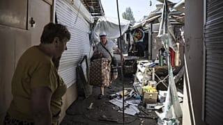 In this photo provided by Ukraine's 24th Mechanized Brigade press service, a seller leaves the market hit by Russia's drone attack in the town of Druzhkivka, Donetsk region