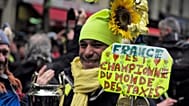 Un manifestante de los chalecos amarillos sostiene un cartel en el que se lee 'Francia es la campeona mundial de los impuestos' durante una protesta en París en 2019,