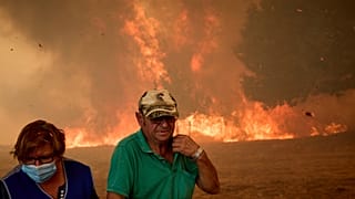 Des habitants luttent contre un feu de forêt qui progresse vers le village de Rebordondo, près d'Ourense, dans le nord-ouest de l'Espagne, le lundi 18 août 2025
