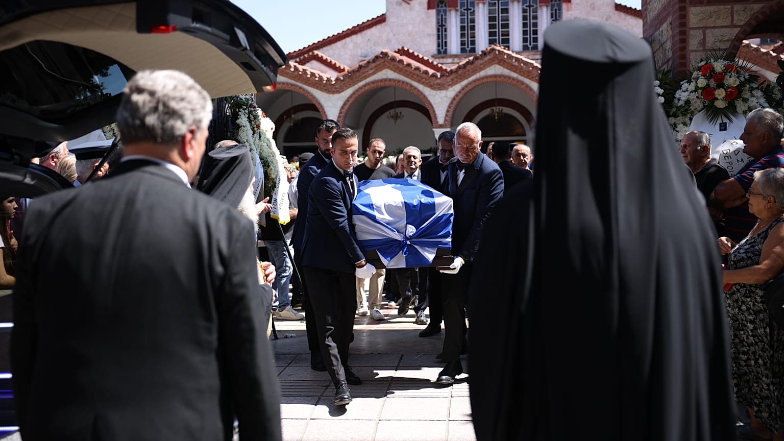 Σκεπασμένο με την ελληνική σημαία το φέρετρο με τη σορό του Απόστολου Βεσυρόπουλου μεταφέρεται κατά τη διάρκεια της κηδείας του
