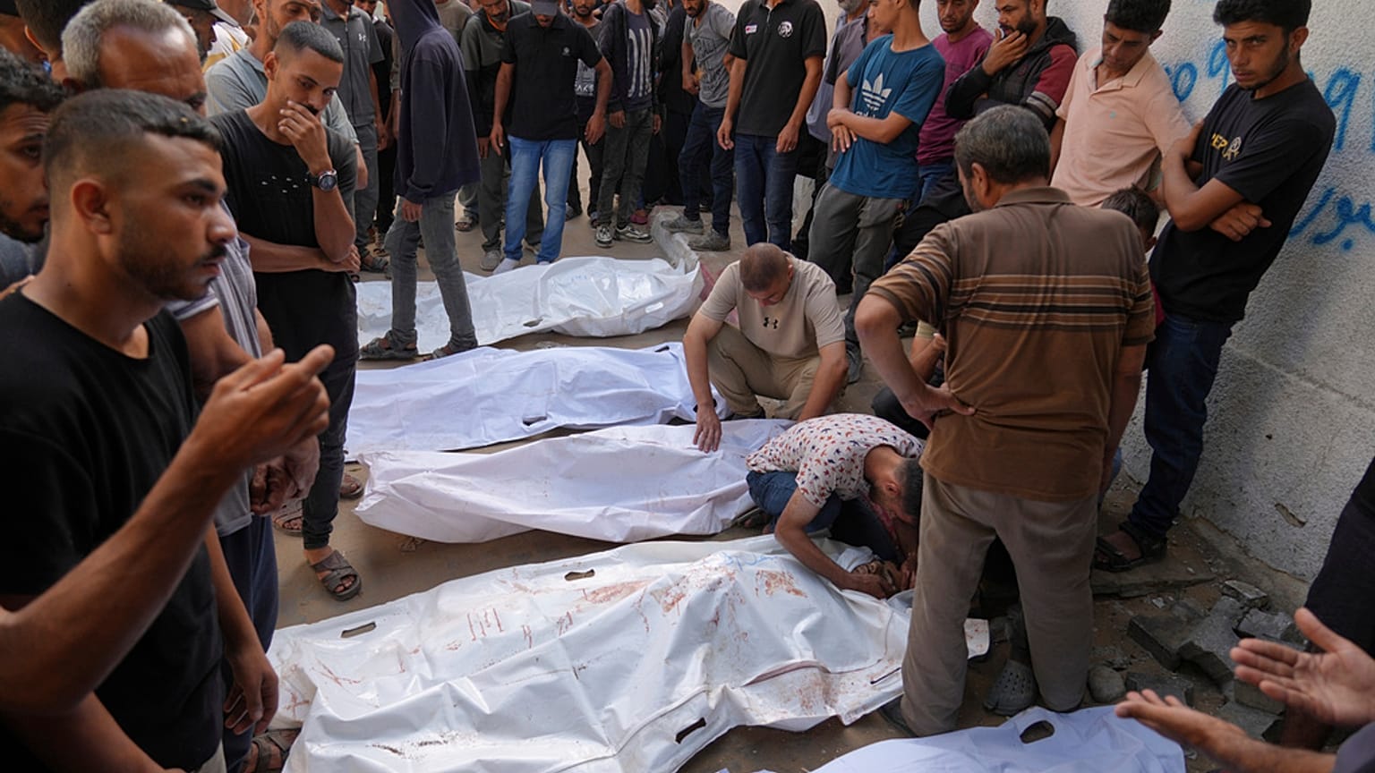 فلسطينيون ينعون جثث أشخاص قتلوا إما في غارات عسكرية إسرائيلية أو أثناء محاولتهم الوصول إلى شاحنات المساعدات، خارج مستشفى الشفاء في مدينة غزة، الخميس 21 أغسطس/آب 2025.