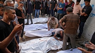 فلسطينيون ينعون جثث أشخاص قتلوا إما في غارات عسكرية إسرائيلية أو أثناء محاولتهم الوصول إلى شاحنات المساعدات، خارج مستشفى الشفاء في مدينة غزة، الخميس 21 أغسطس/آب 2025.