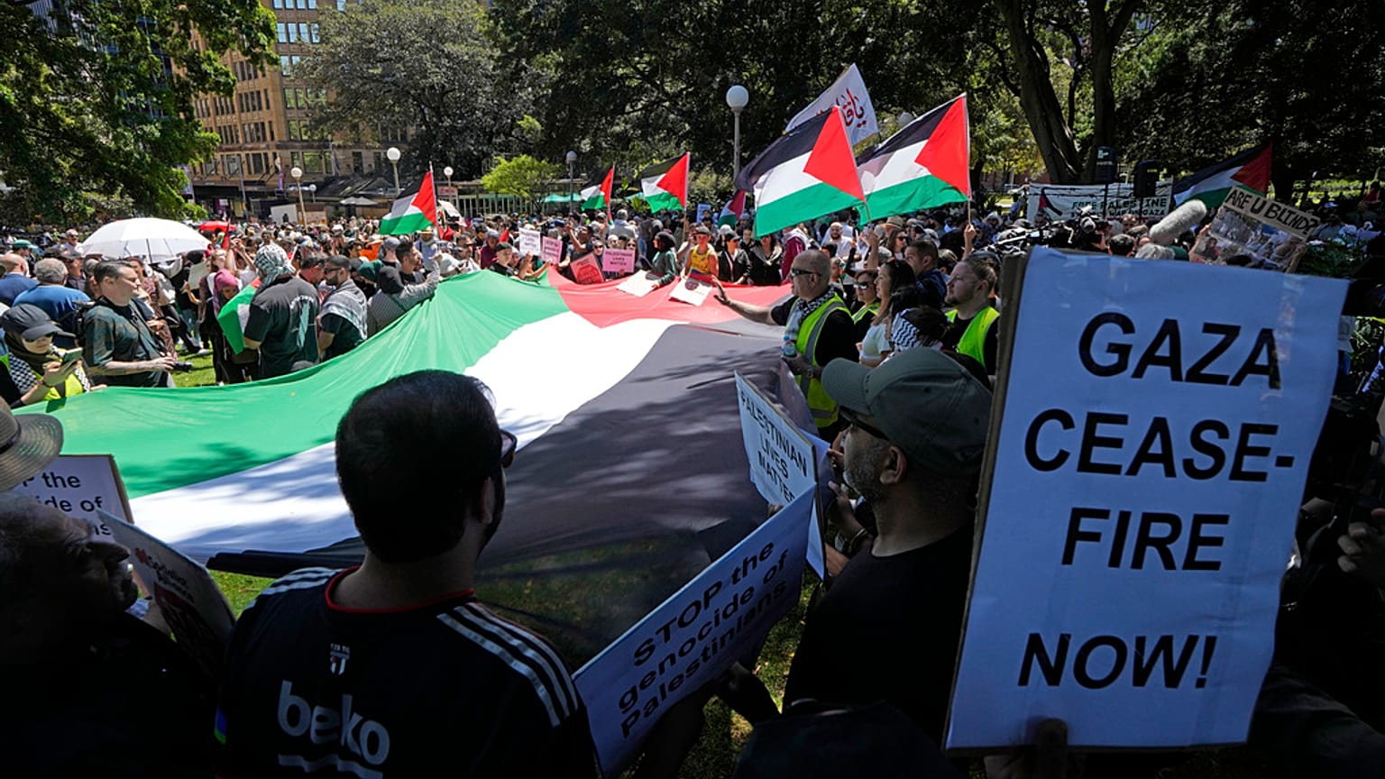 تم وضع علم فلسطيني كبير بينما يتجمع الناس في وسط سيدني لحضور تجمع حاشد يوم الأحد, أكتوبر. 15 يناير 2023