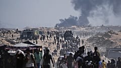 Filistinliler, 23 Ağustos 2025, Cumartesi günü Gazze Şeridi'nin kuzeyindeki Beyt Lahiya'nın dış mahallelerinde bir insani yardım konvoyundan indirilen un çuvallarını taşıyor.