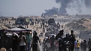 Palestinians carry sacks of flour unloaded from a humanitarian aid convoy on the outskirts of Beit Lahiya, northern Gaza Strip, Saturday, Aug, 23, 2025