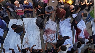فلسطينيون يحزنون على جثث أشخاص قتلوا إما في غارات عسكرية إسرائيلية أو أثناء محاولتهم الوصول إلى شاحنات الإغاثة, خارج مستشفى الشفاء,في مدينة غزة, الخميس, أغسطس. 21, 2025.