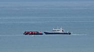 FILE - A boat thought to carry migrants is escorted by a vessel from the French Gendarmerie Nationale in the English Channel off Wimereux, France, Wednesday, Sept. 4, 2024
