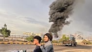 Άνθρωποι οδηγούν μια μοτοσικλέτα καθώς καπνός αναδύεται μετά από ισραηλινές αεροπορικές επιδρομές σε πολλές περιοχές, συμπεριλαμβανομένου ενός πλανήτη ενέργειας και ενός πρατηρίου βενζίνης στη Σανάα της Υεμένης, Κυριακή 24 Αυγούστου 2025.