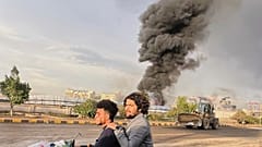 Menschen fahren auf einem Motorrad, während Rauchschwaden nach israelischen Luftangriffen auf mehrere Gebiete, darunter ein Kraftwerk und eine Tankstelle, in Sanaa, Jemen, Sonntag, 24. August 2025, aufsteigen.
