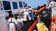 Auf diesem von RESQSHIP zur Verfügung gestellten Foto evakuieren Mitarbeiter der italienischen Küstenwache Migranten vom Schiff NADIR vor der Küste von Lampedusa, Samstag, 23. August 2025.