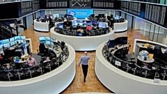 Um homem caminha pelo mercado de acções em Frankfurt, Alemanha, quinta-feira, 13 de março de 2025. 