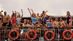 Teilnehmer gestikulieren an Bord einer Fähre auf dem Weg zum Start des Schwimmrennens über die Bosporusstraße in Istanbul, Türkei, am 24. August 2025.