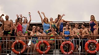 Competitors gesture while aboard a ferry heading to the start swimming race across the Bosphorus Strait, in Istanbul, Turkey, Aug. 24, 2025. 