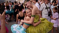 Daria Toma, de 15 años, a la derecha, y Dora, de 10, del Estudio de Ballet de la Ópera Nacional de Rumanía, se abrazan en el exterior del Museo Nacional de Historia de Rumanía durante la Noche de la Danza.