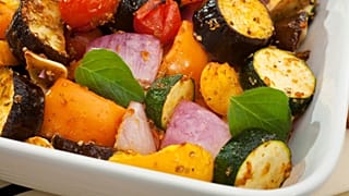 É apresentado um prato com muitos legumes.
