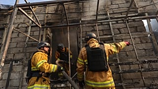 FILE - Rescue workers put out a fire at commercial stores, destroyed by a Russian missile attack on Zaporizhzhia, Ukraine, Monday, Aug. 18, 2025. 
