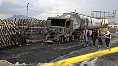 أشخاص يسيرون بجوار حطام شاحنة وقود دمرت في غارات جوية إسرائيلية يوم الأحد، في صنعاء، اليمن، الاثنين 25 أغسطس 2025. 