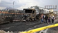La gente camina junto a los restos de un camión de combustible destruido en los ataques aéreos israelíes el domingo, en Saná, Yemen, el lunes 25 de agosto de 2025.