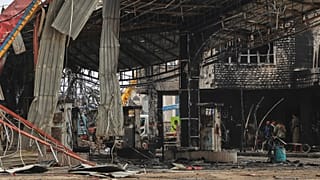 Pessoas inspeccionam uma bomba de gasolina danificada, atingida por ataques aéreos israelitas em Sanaa, 25 de agosto de 2025