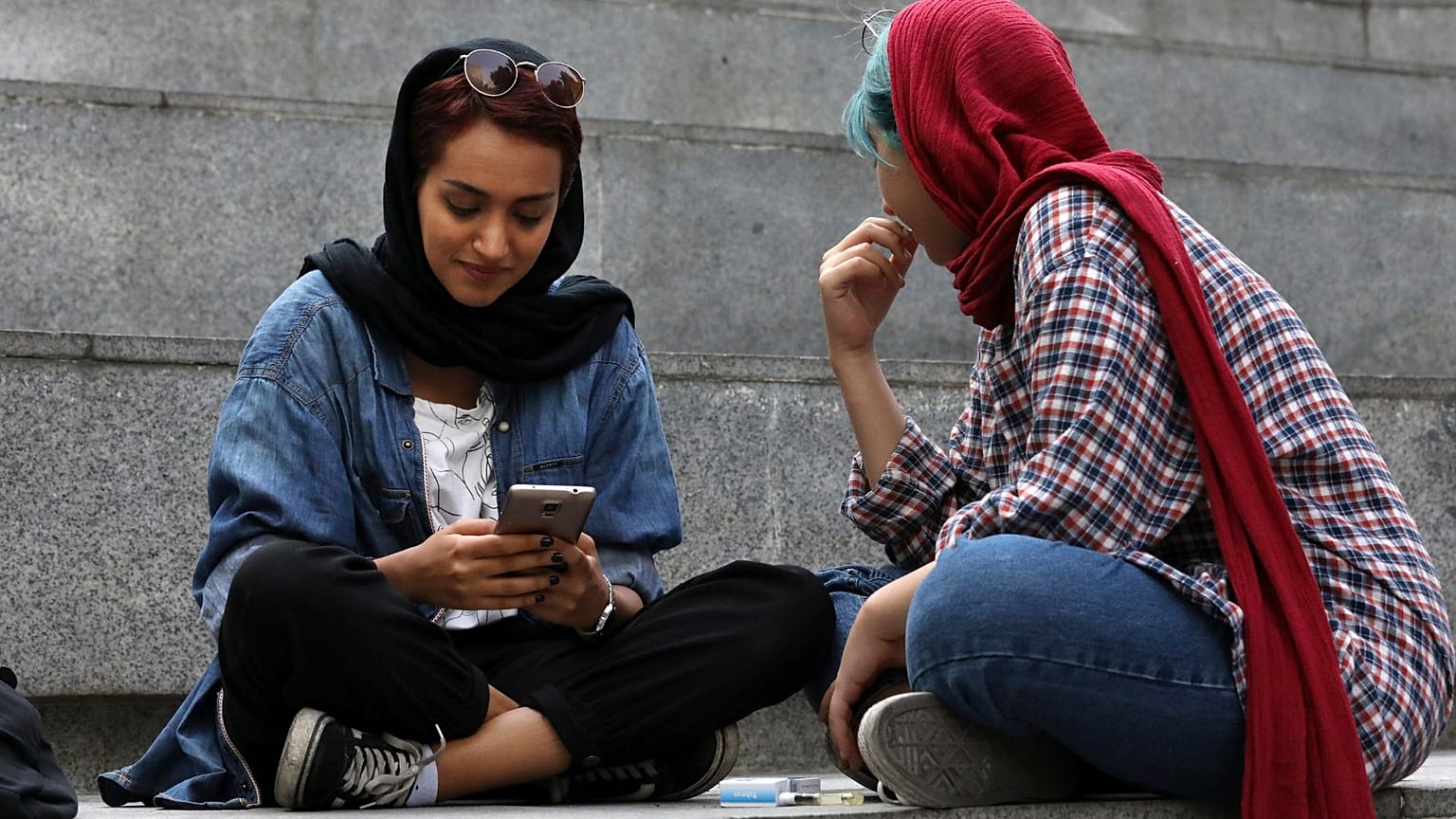 دو زن جوان ایرانی مشغول استفاده از تلفن همراه