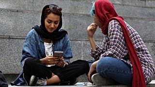 دو زن جوان ایرانی مشغول استفاده از تلفن همراه