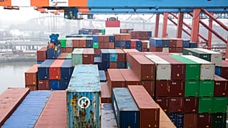 Выгрузка контейнеров с торгового судна в порту Гамбурга.