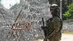 Ένας συνοριοφύλακας φυλάει σκοπιά στα σύνορα Πολωνίας-Λευκορωσίας, ενώ στο βάθος διακρίνονται συρματοπλέγματα στο πολωνικό συνοριακό φυλάκιο στο Polovce